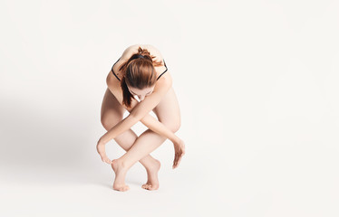 Obraz na płótnie Canvas brunette girl shows different elements of ballet on a white background