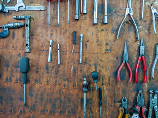 Mechanics tools for repairing an fixing organized on wooden panel board consisted of different sets of tools, like pliers and screwdrivers