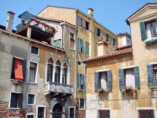 Naklejka premium Bottom view of ancient Venetian street buildings on a clear sunny day.