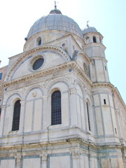 Bottom view of the architectural grandeur of the amazing beauty of the sculptural compositions of Venetian temples and cathedrals in the middle of a summer sunny day.
