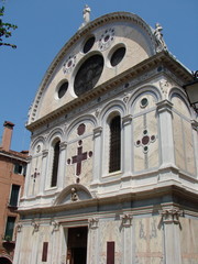 Fototapeta premium Bottom view of the architectural grandeur of the amazing beauty of the sculptural compositions of Venetian temples and cathedrals in the middle of a summer sunny day.
