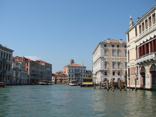 Fototapeta na wymiar The beauty of the unique Venetian architecture surrounded by water streets and avenues against the backdrop of a clear blue summer sky.
