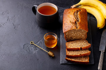 Healthy vegan oat and banana loaf bread, cake. Dark background. Copy space.