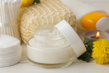 Various personal care products. Face cream, Soap, Cotton pads, washcloth, sticks and yellow flowers on a white background. spa