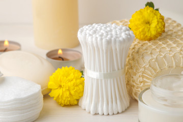 Fototapeta na wymiar Various personal care products. Cotton pads close-up and sticks and yellow flowers on a white background