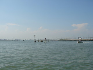 Seascape from the deck of a boat on a barely cloudy blue sky background.