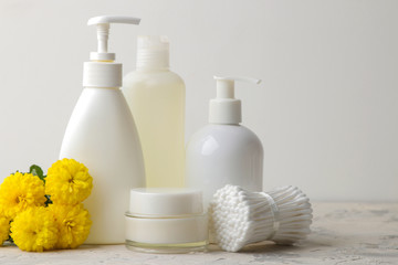 Various personal care products. Face cream, soap, washcloth, sticks and yellow flowers on a white background. spa