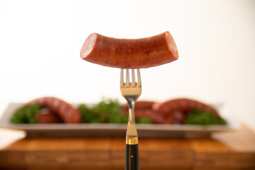 Freshly grilled sausage on fork