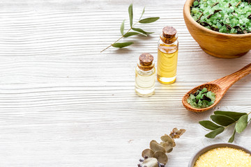 Spa set with mineral salt and oil on white wooden background copy space