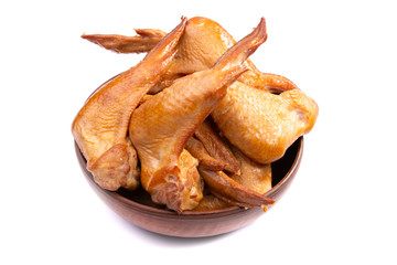 smoked chicken wings, cherry tomatoes in a clay plate on a white isolated background