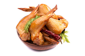 smoked chicken wings, cherry tomatoes in a clay plate on a white isolated background