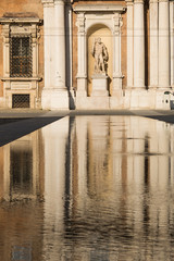 Sculpture with reflection in water. Palazzo Ducale on square Piazza Roma. Modena, Italy