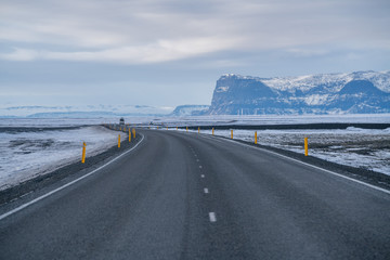 Rural curve highway road among the snow mountain in Iceland