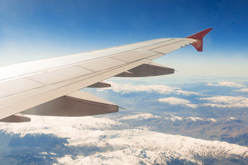 view from the window of the plane that flies over the mountains