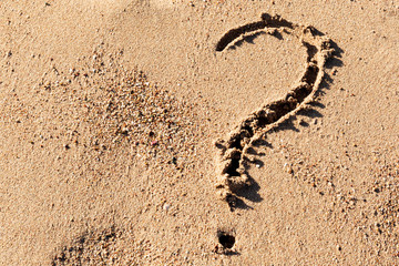 Fototapeta na wymiar Question mark sign on sand beach near the sea. Concept of dilemma, answer and question