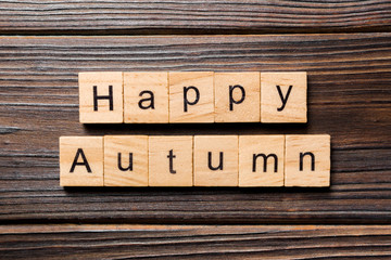 Happy autumn word written on wood block. Happy autumn text on wooden table for your desing, concept