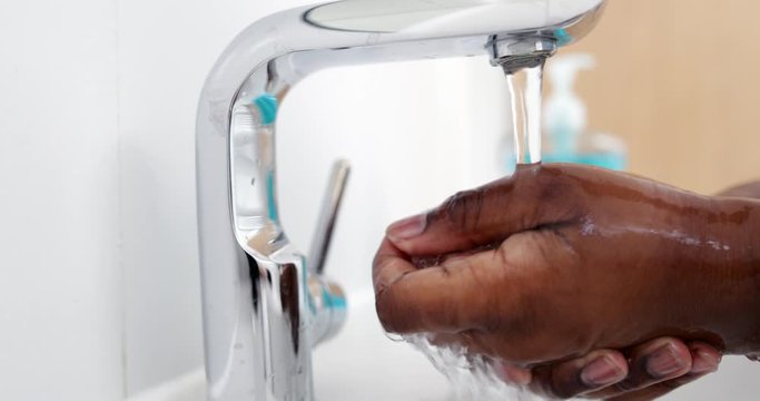 Close Up Of Boy Rinsing Hands With Water At Home To Prevent Infection