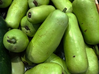 Green gourd displayed at the fresh produce section of a grocery store.