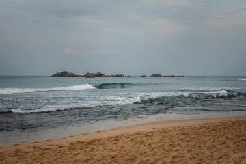 Fototapeta na wymiar cloudy weather, overcast skies, grayness and waves on the Indian Ocean in Hikkaduwa on Sri Lanka