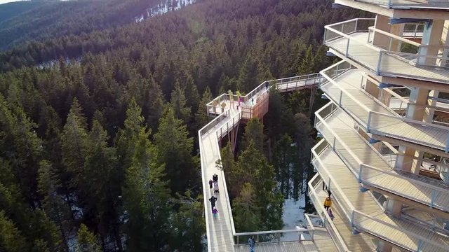 Drone shot of the surrounding walkways of Pohorje treetop where unrecognizable people enjoy the view