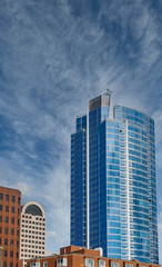 Fototapeta na wymiar A modern blue glass office tower rising from classic older buildings in Seattle