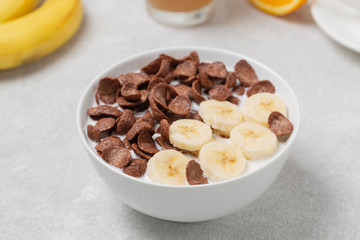 Crispy chocolate flakes in a bowl with milk and banana. Delicious healthy Breakfast