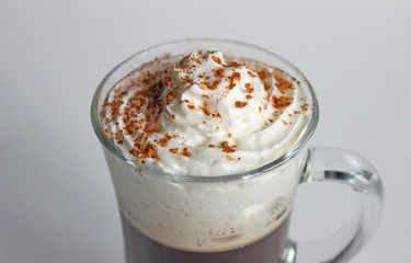A view of a cappuccino in a cup, shot from above. The cup shows cream in the cup