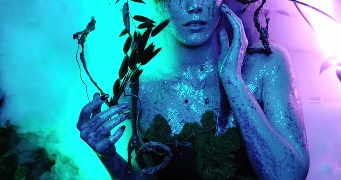 Fantasy world around magical smoke in a neon glow different colors blue, turquoise, purple, fairy elf girl lies in the fog. 4k resolution close-up top view