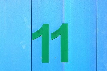 BRIGHT AND COLOURFUL NUMBERS ON WOODEN DOORS OF BEACH HUTS AT TRADITIONAL BRITISH SEASIDE RESORT