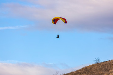 Skydiver On Colorful Parachute In Sky. Active Hobbies
