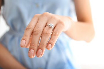 Young woman wearing beautiful engagement ring, closeup