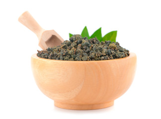 Dry green oolong tea in wooden bowl an isolated on white background. Clipping path.