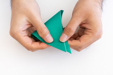 折り紙で鶴を折る男の手元