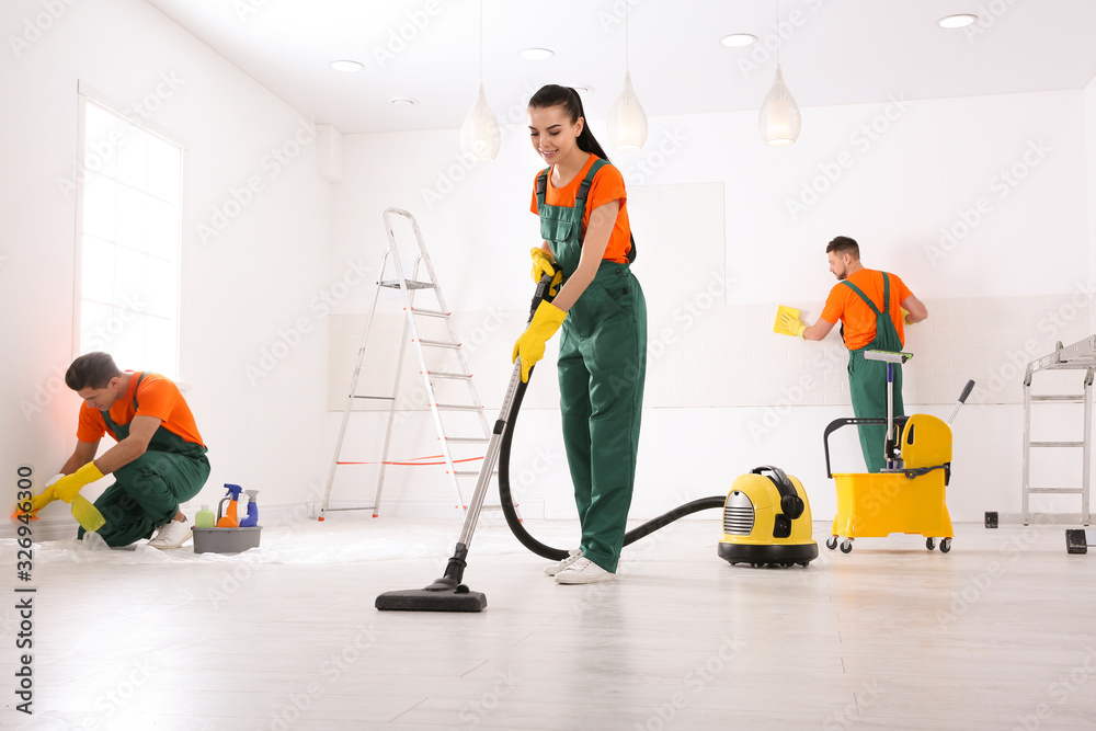 Poster Team of professional janitors cleaning room after renovation