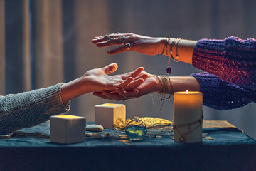 Witch woman spelling over hand palm during occult spiritual rite and divination ritual around...