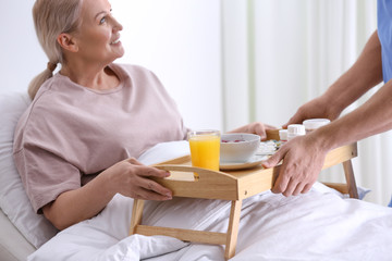 Male nurse bringing food and medicine for patient in hospital ward, closeup. Doctor's prescription