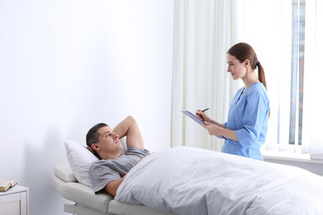 Doctor visiting her patient in hospital ward