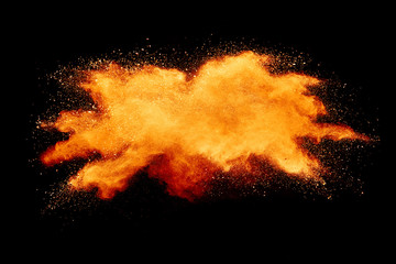 Abstract orange powder explosion isolated on black background.