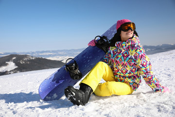 Fototapeta na wymiar Young woman with snowboard on hill. Winter vacation