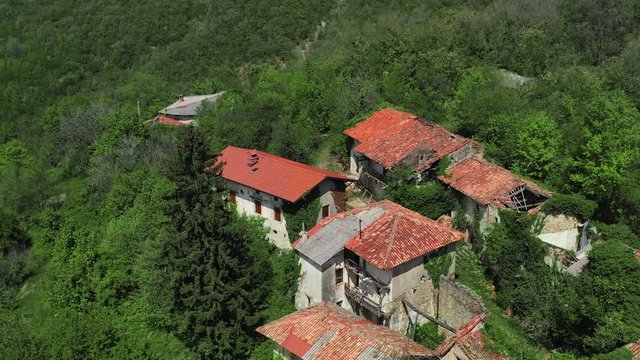 Drone descends near decaying abandoned buildings of historic Slapnik village, Slovenia