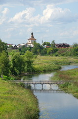 Fototapeta na wymiar Summer view of the Kamenka river and the Church of Kosma and Damian in Korovniki in Suzdal. Golden ring of Russia
