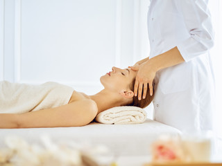 Obraz na płótnie Canvas Beautiful woman enjoying facial massage with closed eyes. Spa treatment concept in medicine