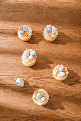 Fototapeta na wymiar Top view of delicious cupcakes with decorative bunny on wooden background