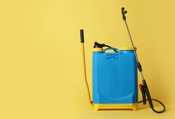Manual insecticide sprayer on yellow background, space for text. Pest control