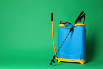 Manual insecticide sprayer on green background, space for text. Pest control