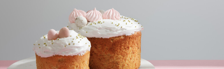 Delicious easter cakes on round board on grey background, panoramic shot