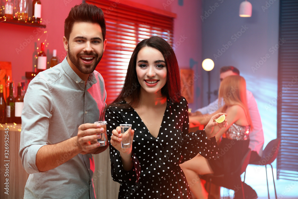 Wall mural young couple with mexican tequila shots in bar