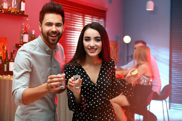 Young couple with Mexican Tequila shots in  bar