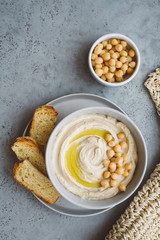 Hummus plate with olive oil and chickpeas. Gray background. Copy space