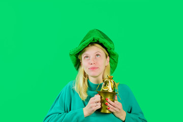 Leprechaun holds pot with gold. Pot with gold. Gold. Saint Patrick's Day. Smiling girl in...